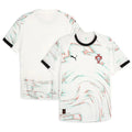 Portugal Away Football Shirt 2024 Puma off-white cream showing all-over multicolor red teal green pointillist dot swirl wave pattern across full shirt front and back FPF red cross crest blue Quinas shield black Puma leaping cat logo black crew neck collar black cuff trim Puma RE:FIBRE badge at hem front and back view on white background