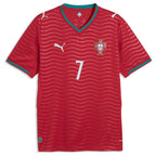 Portugal Home Football Shirt 2026 Puma crimson bright red showing tonal red horizontal wave ripple jacquard texture pattern across full shirt FPF red cross crest blue Quinas shield white Puma leaping cat logo No.7 white on chest teal emerald green V-neck collar 4-pointed star detail teal cuff trim Puma DRYCELL RE:FIBRE badge front flat lay view on white background