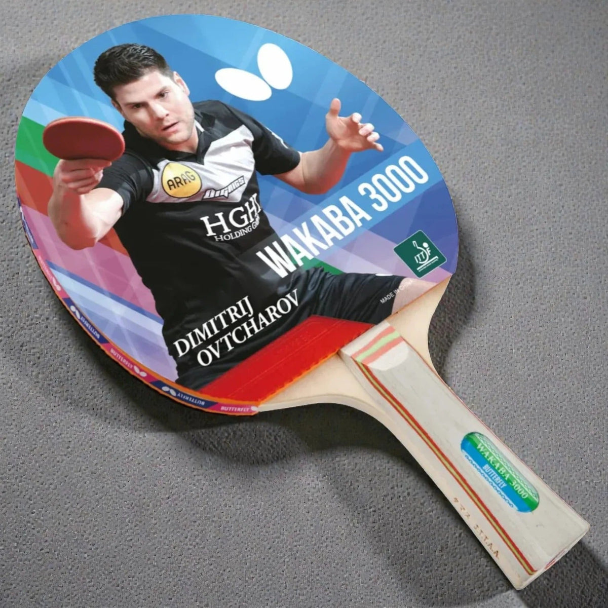 Butterfly Wakaba 3000 Table Tennis Racket front face showing Dimitrij Ovtcharov photo label ITTF approved badge and striped wooden handle - product front view