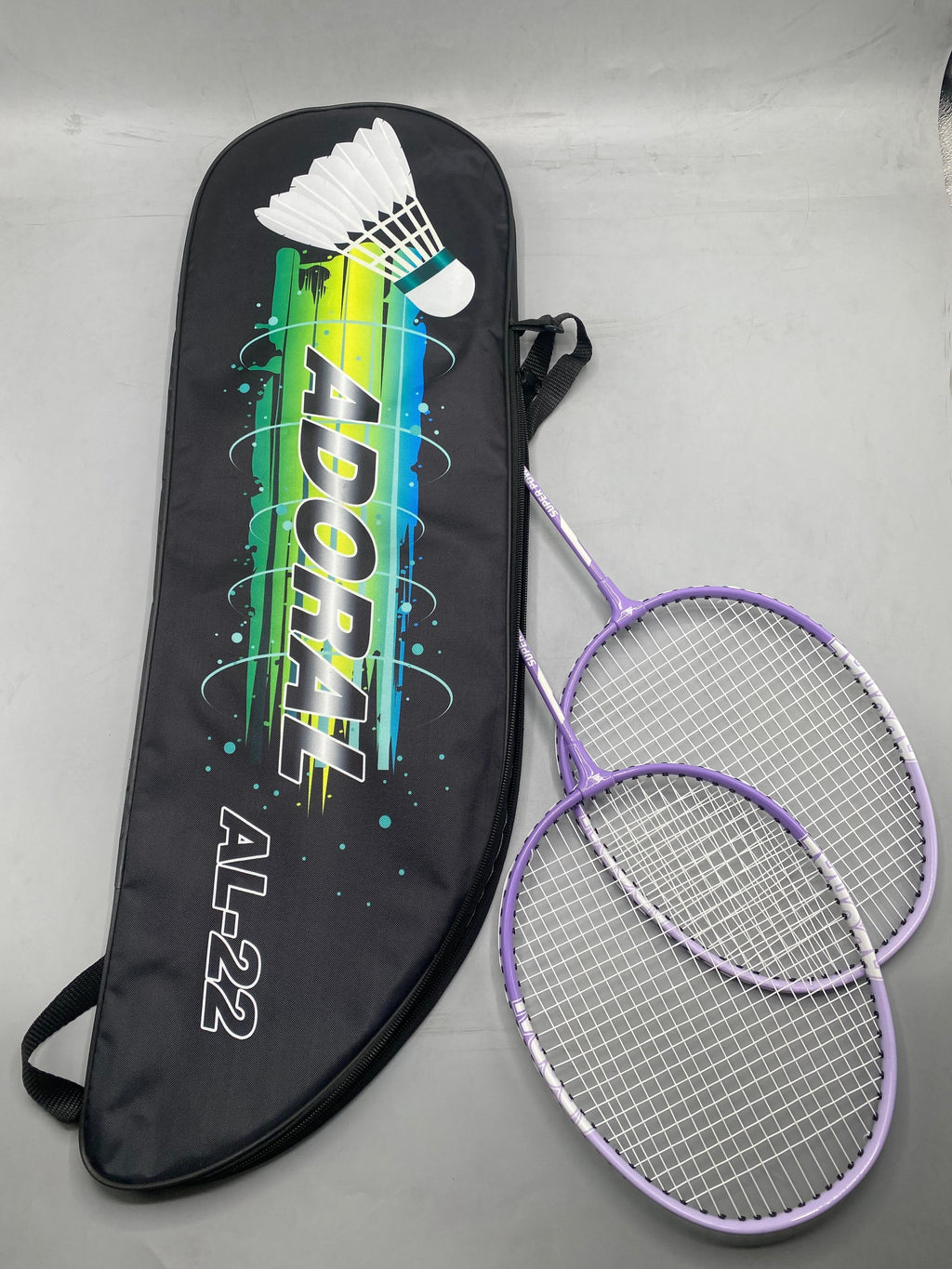 Adoral AL-22 pro lightweight badminton racket set 2 purple rackets leaning against black Adoral AL-22 carry bag - side view