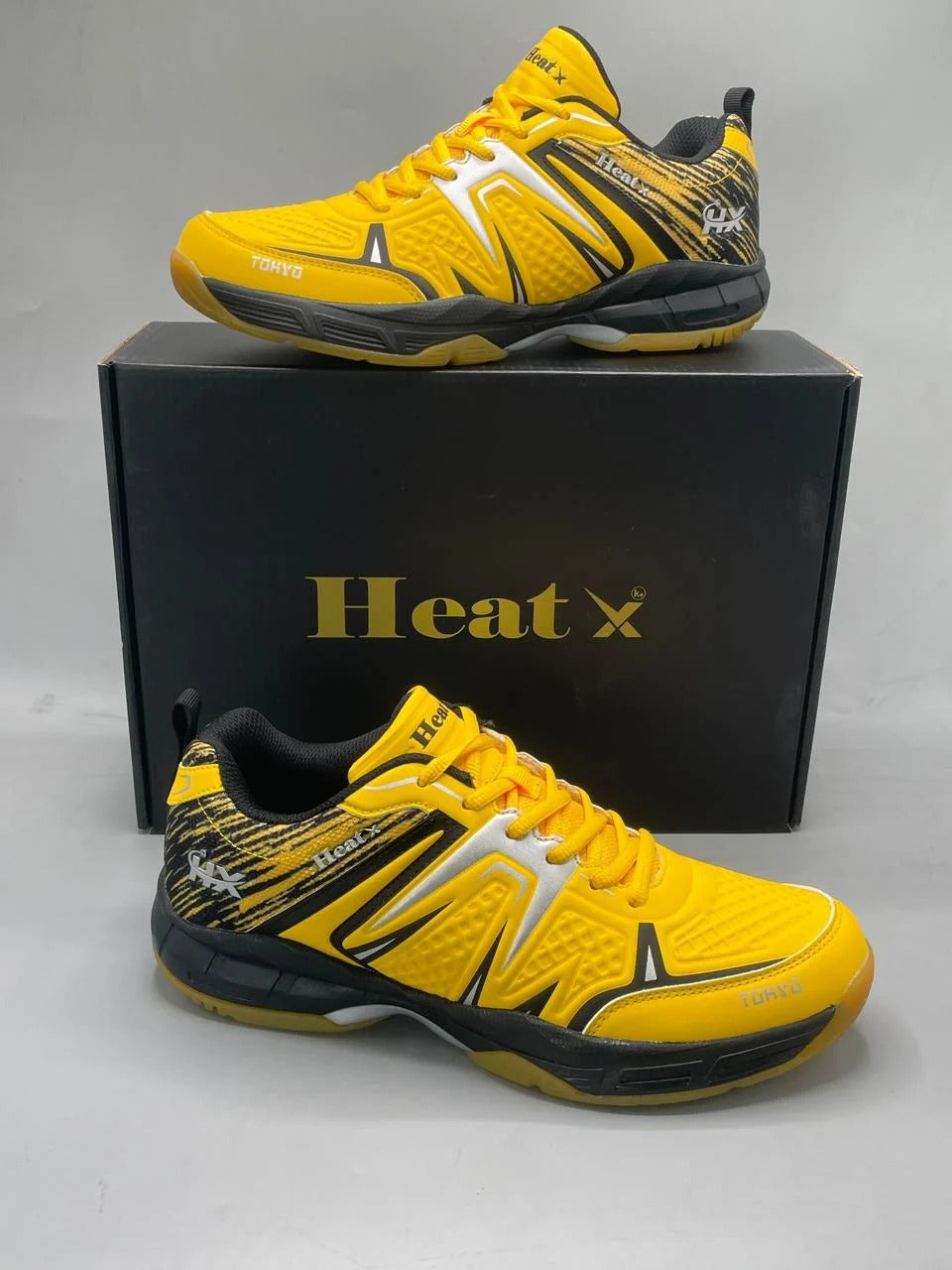 Heat X Tokyo badminton shoes yellow black pair side view showing Tokyo branding and non-slip hexagonal sole