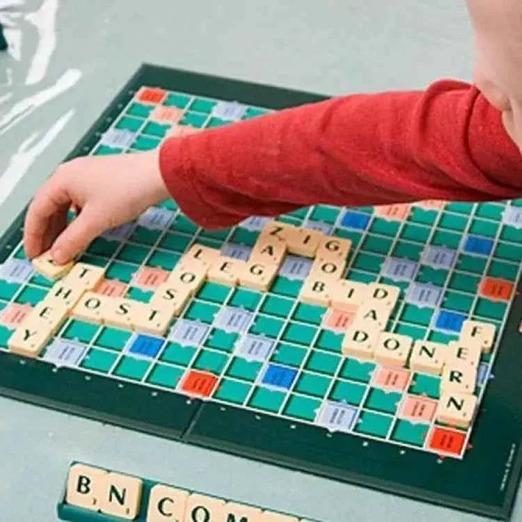 Child placing letter tiles on Scrabble board during gameplay