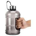 2.2 Litre Large Gym Water Jug smoked grey transparent body with stainless steel screw cap built-in side handle and black carry strap - hand holding bottle side view